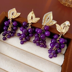 Detail of vintage French grape earrings with purple beads and rhinestones on gold metal