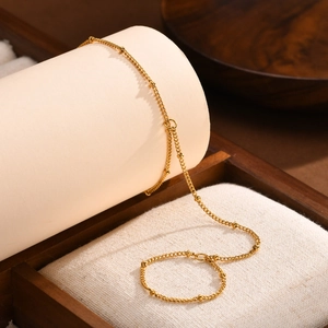 Detailed macro shot of a golden double-layered snake chain bracelet on a display stand