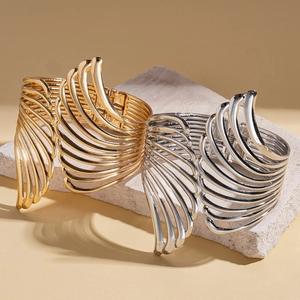 Exaggerated metal wing open cuff bracelets in gold and silver finish on stone