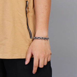 Close-up of vintage square linked steel bracelet on wrist with woven texture detail