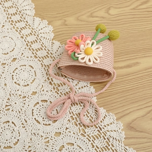 Close-up of pink straw crossbody bag with handmade 3D knit flowers and zipper detail