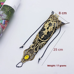 Detail of gothic black lace arm jewelry with yellow gemstone and adjustable drawstring