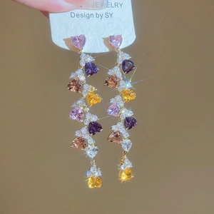 Detail of long tassel earrings with multicolored heart crystals in gold prong settings