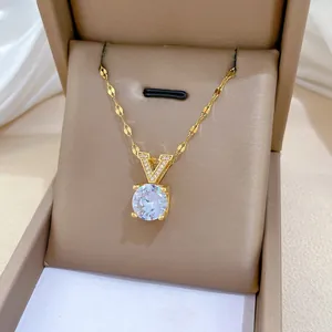 Détail du collier en V doré avec pendentif en zircon rond posé dans son écrin à bijoux