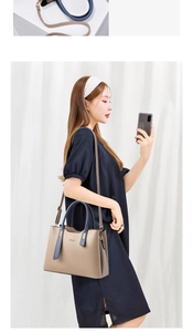 Detail of a beige and navy blue patchwork handbag featuring detachable shoulder strap