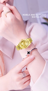 Close-up of elegant gold watch with diamond bezel and Roman numerals on model's wrist