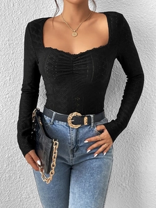 Detail of black square neck long sleeve top with eyelet embroidery and lace trim