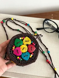 Detail of bohemian handmade coconut shell crochet mini bag with colorful heart buttons