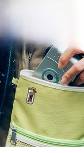 Artistic enamel pin showing paintbrushes in a jar attached to a green canvas bag
