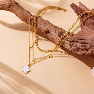 Vintage gold layered necklace featuring a white flower pendant and chunky chain detail