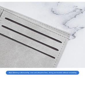 Close-up of neat stitching and multiple card slots on slim matte grey wallet