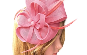 Detail of pink linen fascinator hat with elegant mesh bow and delicate feather accents