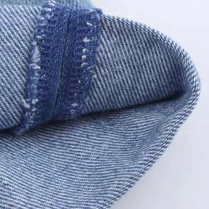 Détails du tissu en denim bleu montrant les coutures et la texture du tissage