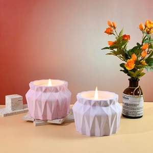 Dettaglio di portacandele profumati geometrici stile origami in rosa e bianco opaco
