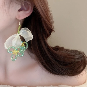 Detail of drop earrings with mesh petals and green beads shown on female model