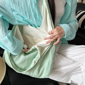 Detail of the mint green tote bag interior showing the inner pocket and soft fabric texture