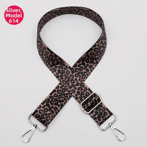 Close-up of leopard print bag strap with adjustable silver metal hooks on grey background