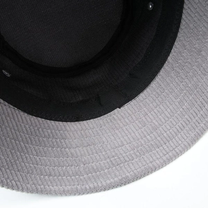 Detail of gray corduroy bucket hat showing stitching quality and black cotton lining