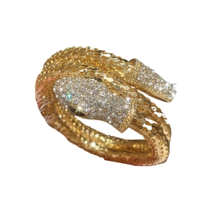 Golden snake wrap bracelet with crystal pavé and detailed scale texture on white background