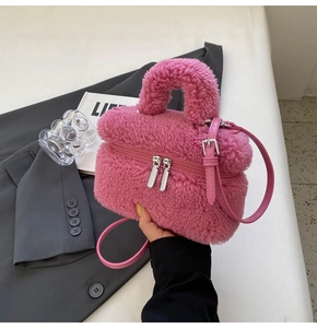 Close-up of pink faux shearling mini tote bag with dual zippers and soft plush texture
