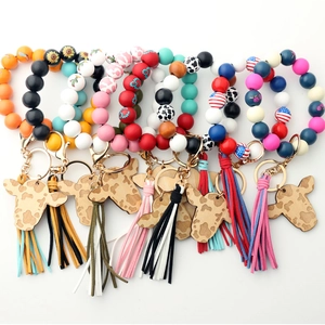 Silicone bead wristlet keychain with sunflower, cow print, wood charm, and tassel fringe