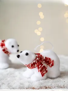 Detailed macro view of white flocked polar bear ornaments with festive red scarves