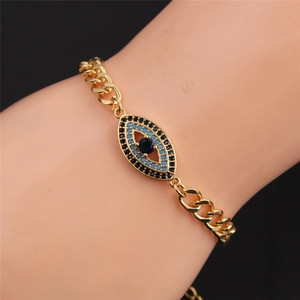 Macro shot of Cuban chain bracelet with gold-plated evil eye charm and colored cubic zirconia