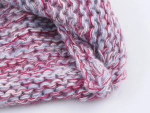Close-up of thick pastel knit fabric with soft pink, blue, and white fuzzy textures