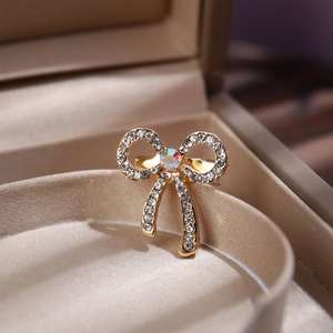 Macro shot of gold butterfly brooch with sparkling crystals on silk ribbon