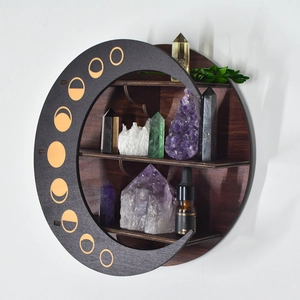 Detailed view of a circular wooden crystal shelf with moon phase patterns and storage slots