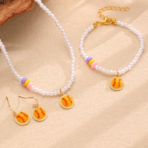 Détail de l'ensemble collier, bracelet et boucles d'oreilles en perles avec pendentifs softball