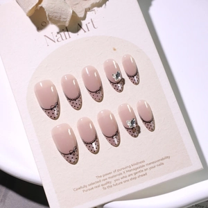 French cat-eye press-on nails with black dots, bow designs, and 3D silver butterflies
