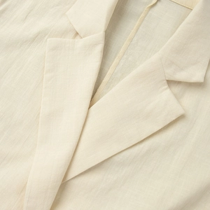Macro view of the tailored notch lapel and breathable linen-cotton fabric texture