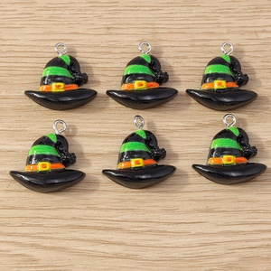 Detail of 6 black Halloween witch hat charms with green stripes on a wooden surface