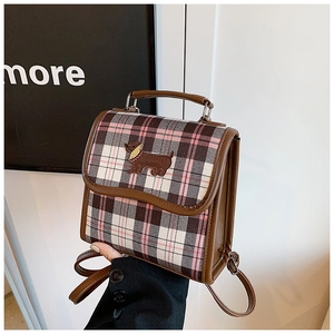 Detail of vintage plaid backpack featuring cute puppy embroidery and brown leather trim