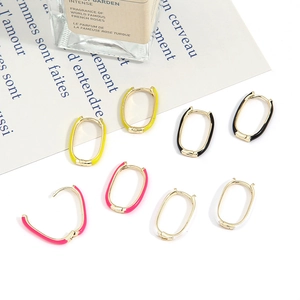 Detail of colorful oval U-shaped hoop earrings in gold finish with enamel inlay