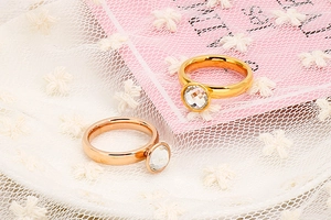 Dettaglio di anelli in acciaio inossidabile oro e oro rosa con pietre di cristallo