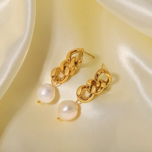 Macro detail of 18K gold-plated Cuban chain earrings with baroque pearls on silk