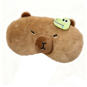 Cute brown capybara plush sleep mask with mini green dinosaur accessory on white background