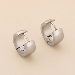 Close-up of wide stainless steel hoop earrings with a brushed matte silver finish