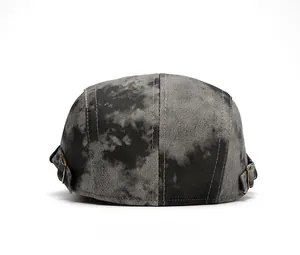 Rear view of tie-dye newsboy cap showing adjustable bronze metal buckles on both sides