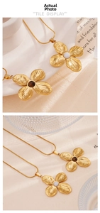 Detailed macro view of gold petal pendant featuring white mother-of-pearl and snake chain