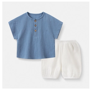 Detail of soft cotton gauze baby set showing textured fabric and wooden buttons
