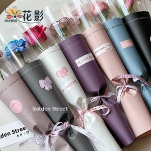 Close-up of waterproof floral wrapping paper with Happy Women's Day text and ribbon