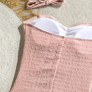 Detail of pink smocked one-piece swimsuit fabric with built-in pads and tie straps