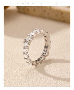 Macro shot of silver S925 eternity ring with sparkling stones on beige background