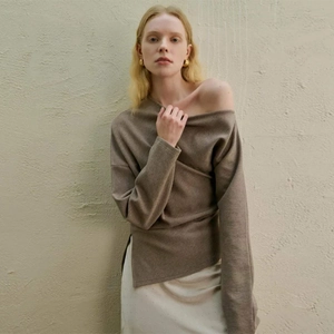 Close-up of brown off-shoulder knit top featuring an asymmetric neckline and ribbed texture