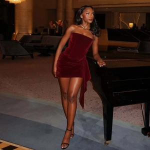 Detail of dark red velvet bodycon dress featuring elegant side drapery and strapless design