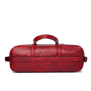 Detail shot of the red cylindrical tote bag featuring a textured PU leather finish