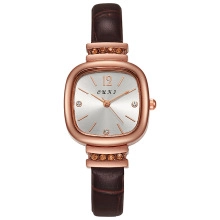 Detail of square rose gold watch dial with brown rhinestones and leather strap